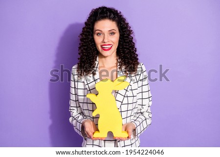 Photo of young cheerful woman happy positive smile hold rabbit figure isolated over purple color background