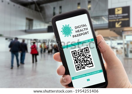Hand holding a smart phone with Digital health or Vaccination passport on screen. Covid-19 passport on airport allowing travel Royalty-Free Stock Photo #1954251406