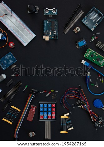 various microcircuits, controllers, sensors, parts, motherboard, cable, wires on a muted black background. copy space. top view. flatlay