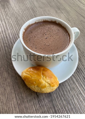 Selective focus of Hot chocolate milk with a pineapple tart cookie on a wooden table. Top view. Copy space.