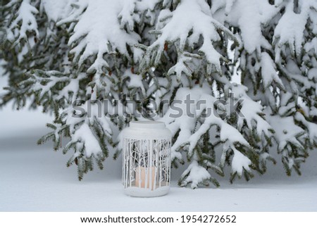 Horizontal photo of a rustic birch tree candle decoration set in snow