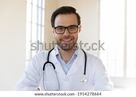 Profile picture of smiling young Caucasian male doctor in white medical uniform show good quality service in hospital. Headshot portrait of happy man GP or pediatrician in clinic. Healthcare concept.
