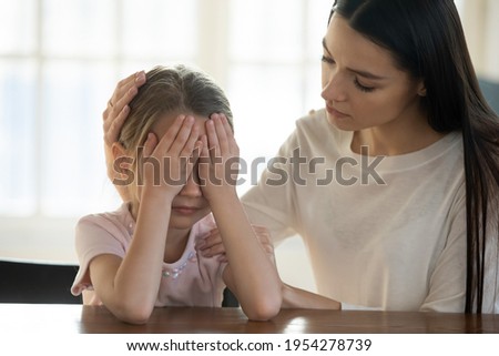 Caring young Caucasian mother comfort caress upset sad little daughter having bullying problems at school. Loving mom support unhappy small girl child crying feeling bad. Family trouble concept. Royalty-Free Stock Photo #1954278739