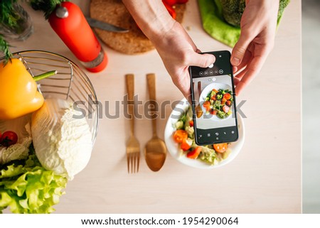 blogger guy taking pictures of salad in the kitchen. cooking healthy food