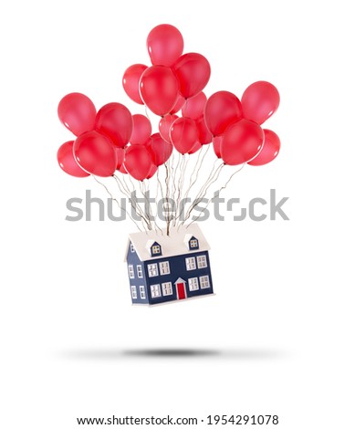 Toy house lifted up with red balloons isolated on a white background. House prices rising and moving home concept