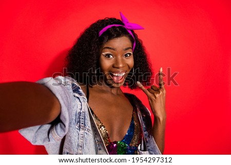 Photo of pretty impressed curly dark skin woman dressed pinup clothes tacking selfie showing hard rock sign isolated red color background