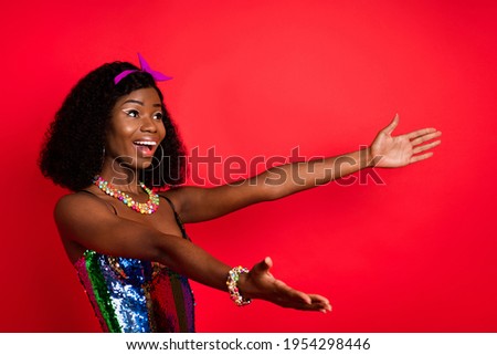 Photo of cute charming curly dark skin woman dressed pinup clothes open arms empty space smiling isolated red color background