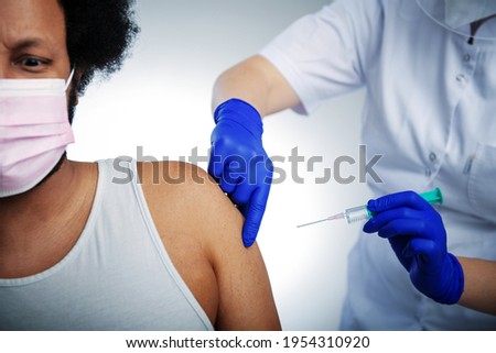 Prevention, immunization and treatment of coronavirus infection. African American male patient getting immunized against covid-19, receiving antiviral vaccine injection at health centre