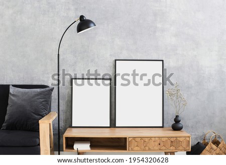 Blank picture frames mock-up on grey wal. Living room design. View of modern rustic style interior with chair. Home staging and minimalism concept