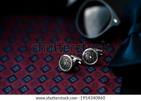 Business accessories. Luxury Men's cufflinks with breastplate and sunglasses close up.