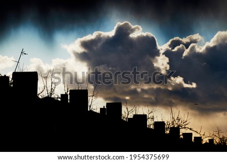 A picture of dramatic clouds over house roofs in a village.