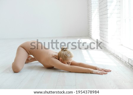 Portrait of gorgeous young woman practicing yoga indoors. Beautiful yoga girl, practice calmness and relax. High quality photo.