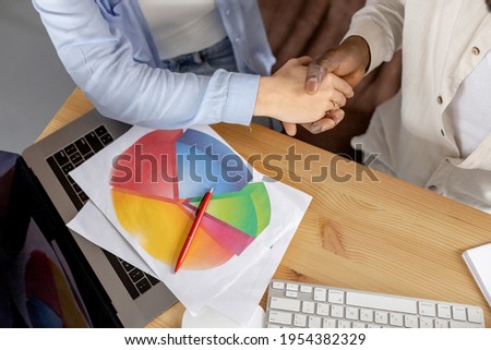 Portrait of multiracial business people shaking hands after successful negotiations, sign a contract. Confident employees having important meeting, come to agreement, collaboration concept
