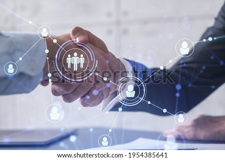 Recruitment concept to hiring of a new talented specialists for international company. Handshake to sign in of employment agreement. Social media hologram icons over the table with documents. Royalty-Free Stock Photo #1954385641