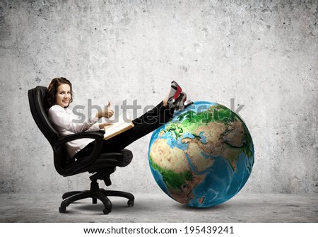 Young businesswoman sitting in chair and reading book. Elements of this image are furnished by NASA