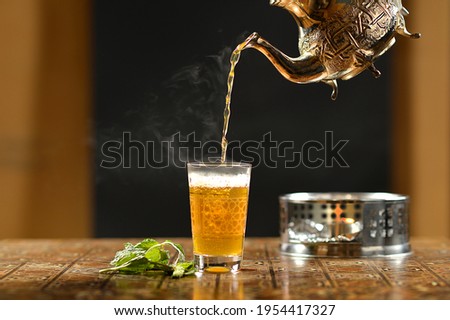 A cup of Moroccan tea, with a teapot Royalty-Free Stock Photo #1954417327
