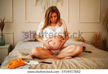 Pregnant Woman In Bedroom With Her Hand At Belly