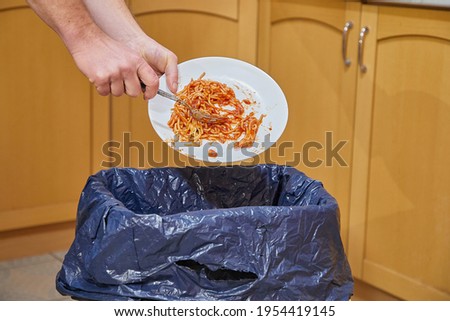 Food leftower thrown in the kitchen garbage bin, food waste problem Royalty-Free Stock Photo #1954419145