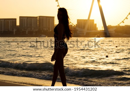 Silhouette of woman at the beach at sunset