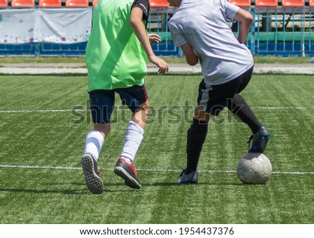 Children's football. An interesting football moment at the match and training. The active struggle and dynamics of the boys' soccer match. The boys are recklessly fighting for the ball.