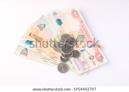UAE Money with coins ,female hands holding Uae money .