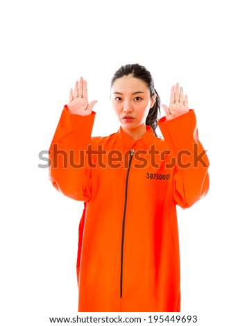 Young Asian woman making stop gesture sign from both hands in prisoners uniform