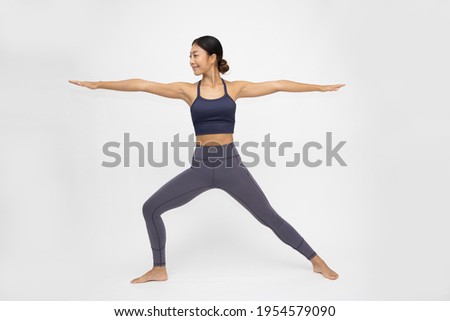 Asian woman doing yoga practices Ashtanga Vinyasa Yoga asana Virabhadrasana 2 or warrior pose 2 isolated on white background Royalty-Free Stock Photo #1954579090