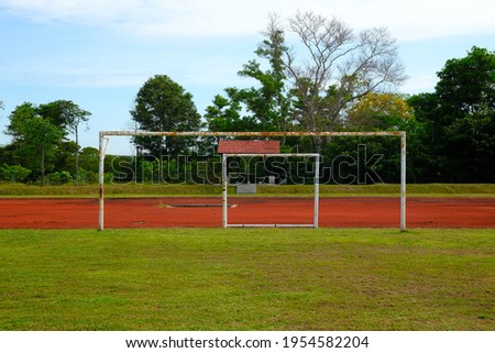 Selective focus and noise effect picture of rusty goalpost still used in the football field that can cause hazard to player