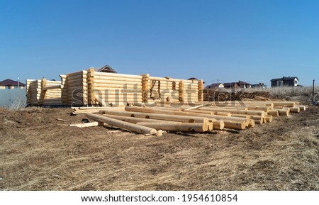 Construction of a wooden house on a sunny day in spring. New log house against the blue sky Royalty-Free Stock Photo #1954610854