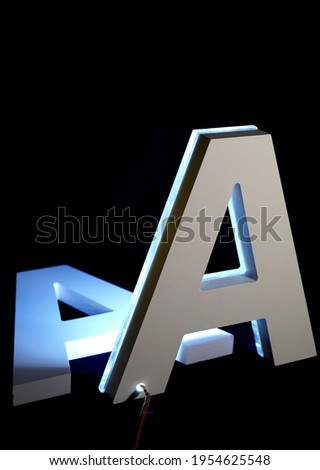 Letter A made from PVC and iluminated with blue neon light isolated on black background                  
