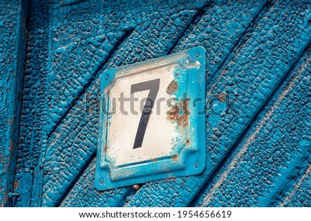 outdoor old blue painted door with number seven