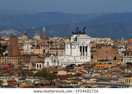 Panorama on the city of Rome, Altare della Patria, roofs, churches and domes and in the distance mountains in the north east area of ​​the city.