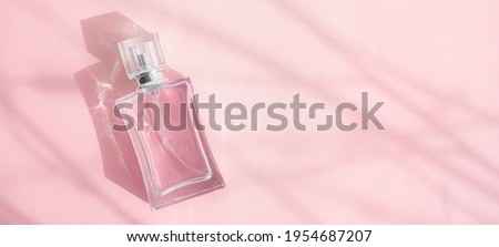A bottle of perfume on a pink background . Pink perfume. Smell. Aromatherapy. An article with a place for the text about the choice of perfume fragrance. Light and shadows. Naturalness . Copy space Royalty-Free Stock Photo #1954687207