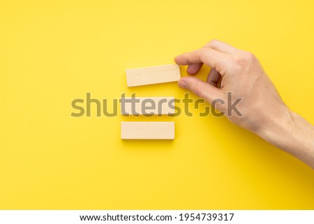 blank wooden blocks stack over yellow background. business strategy template. step notes mockup. above view.