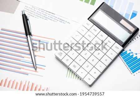 Accounting data, charts, calculator and pen. Many charts and graphs. Reflection background.