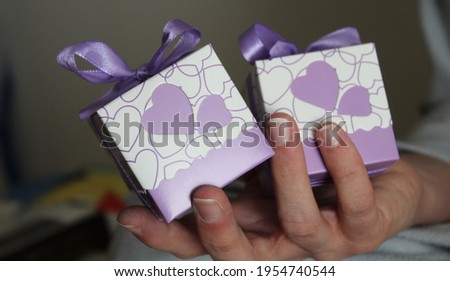 Pair of packages with a bow to give as a gift in the hands of a woman