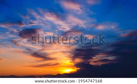 A beautiful photo of a gorgeous spring sunset sky with clouds in shades of orange and blue. Beautiful background for your design, wallpaper, screensaver, site. Great for printing on poster