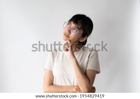 Image of Asian Nerdy lady standing and thinking isolated on white background.,Looking aside.