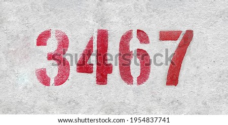 Red Number 3467 on the white wall. Spray paint.