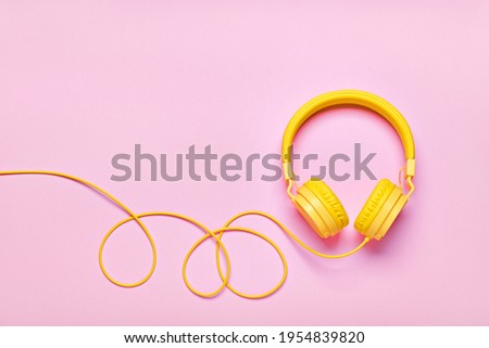 Yellow headphones on pink background. Minimal Music concept, flat lay, copy space