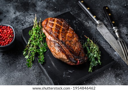 Roasted Christmas duck breast fillet steak. Black background. Top view