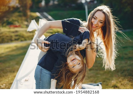 Mother with daughter playing in a summer park