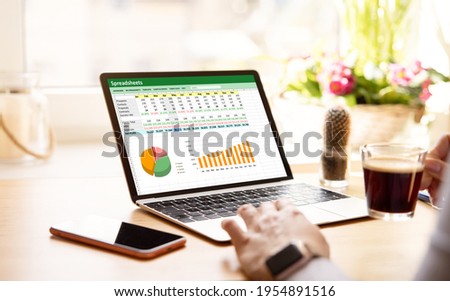 Woman working with spreadsheets on laptop computer Royalty-Free Stock Photo #1954891516