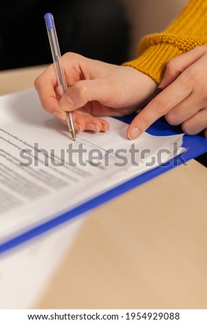 Close up of businesswoman signing investment papers contract with confident partner sitting at desk in startup company. Entrepreneur taking bank loan insurance concept, patent certificate registration