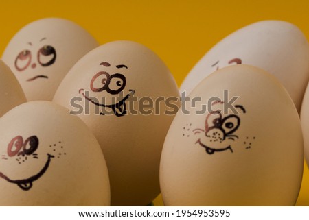 Easter eggs with painted faces and smiles on an yellow  background 
