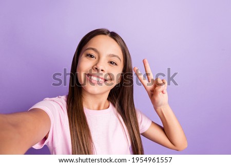 Photo of young girl happy positive smile make selfie show peace cool v-sign isolated over violet color background