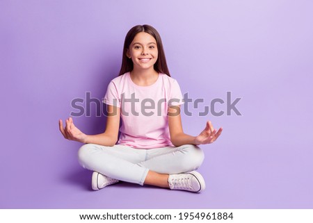 Photo of peaceful sweet young girl wear pink t-shirt sitting floor practicing yoga isolated violet color background