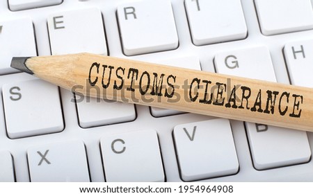 Text Customs Clearance on wooden pencil on white keyboard. Business
