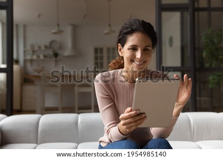 Confident millennial latin woman hold tablet zoom in image photo picture on screen enjoy good work of new web app. Positive young female scroll text on pad read pleasant message email electronic book