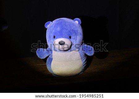 Happy blue bear standing in spotlight